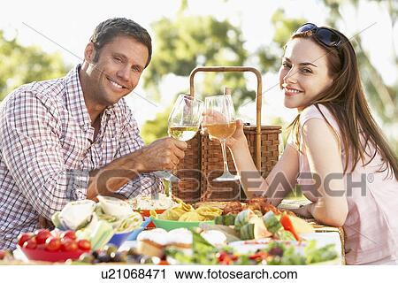 Stock Image - Couple Eating An Al Fresco Meal, Toasting With Wineglasses. Fotosearch