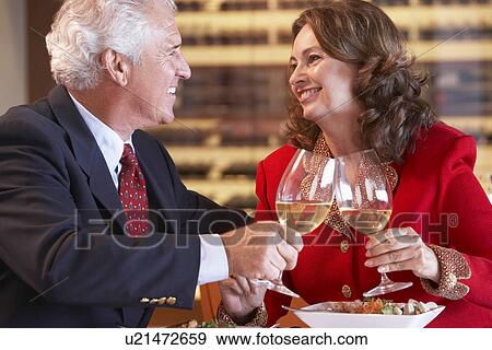 Stock Photo - Couple Eating Dinner And Toasting With A Glass Of Wine. Fotosearch