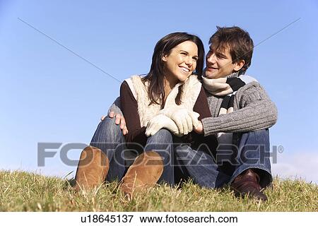 Stock Photo - Couple Sitting In Park Together. Fotosearch