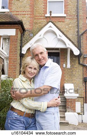 Couple Standing Outside Their House View Large Photo Image Picture - Couple Standing Outside Their House. Fotosearch