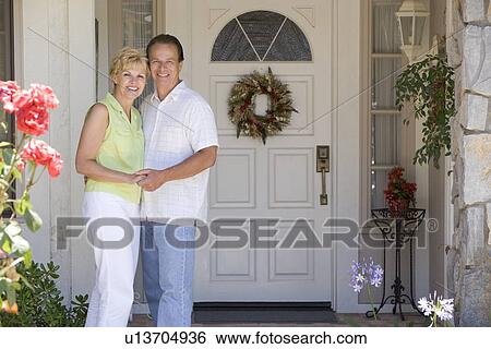 Stock Photograph - Couple Standing Outside Their House. Fotosearch
