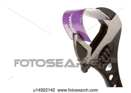 Stock Image - Credit Card Being Held In Wrench Against White Background. Fotosearch