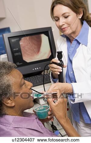 Stock Photo - Doctor Administering Medicine To Patient. Fotosearch