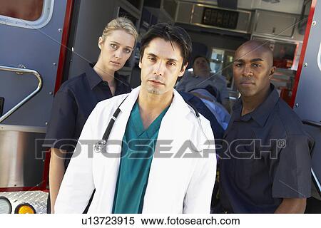 Stock Photography - Doctor and paramedics standing in front of an ambulance. Fotosearch