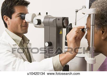 Picture - Doctor Checking Patient's Eyes. Fotosearch