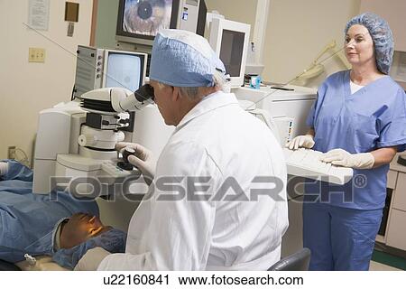 Doctor Checking Patient's Eyes With Nurse Assisting View Large Photo Image Stock Image - Doctor Checking Patient's Eyes With Nurse Assisting. Fotosearch