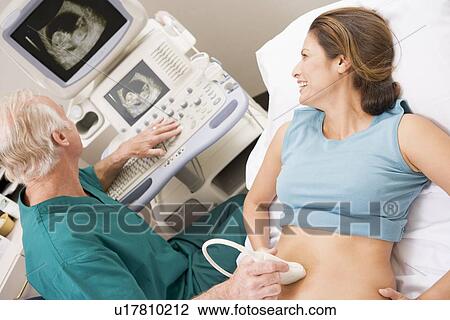 Stock Image - Doctor Giving Patient An Ultra Sound . Fotosearch