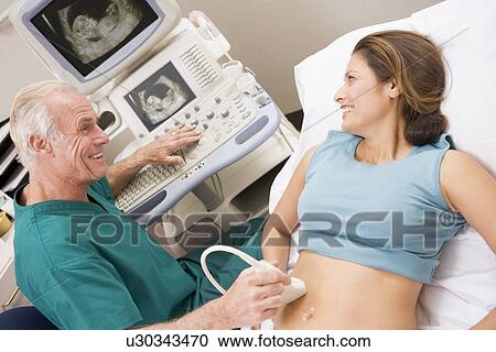 Stock Image - Doctor Giving Patient An Ultra Sound . Fotosearch