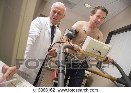 Stock Image - Doctor Monitoring Patient During Health Check. Fotosearch