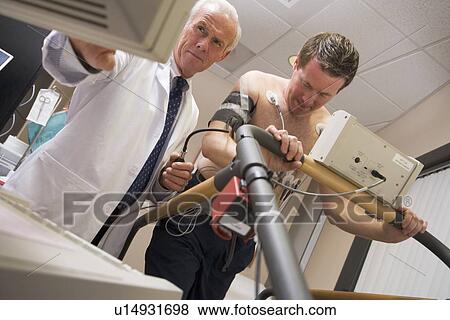 Stock Photo - Doctor Monitoring Patient During Health Check. Fotosearch