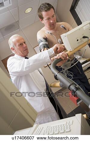 Stock Photo - Doctor Monitoring Patient During Health Check. Fotosearch