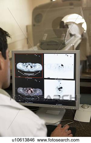 Stock Photograph - Doctor Monitoring Patient Having Computerized Axial Tomography (CAT) Scan. Fotosearch