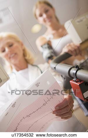 Stock Image - Doctor Monitoring The Heart-Rate Of Patient On A Treadmill. Fotosearch