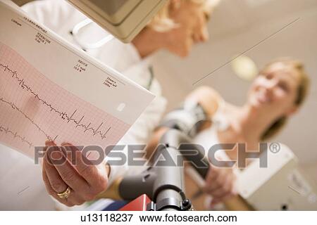 Stock Photo - Doctor Monitoring The Heart-Rate Of Patient On A Treadmill. Fotosearch