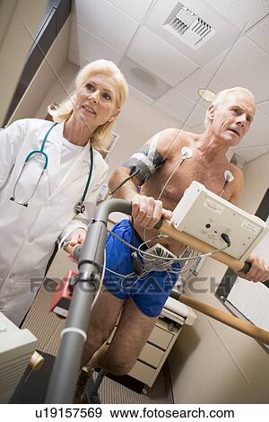 Doctor Monitoring The Heart-Rate Of Patient On A Treadmill View Large Photo Image Stock Photo - Doctor Monitoring The Heart-Rate Of Patient On A Treadmill. Fotosearch