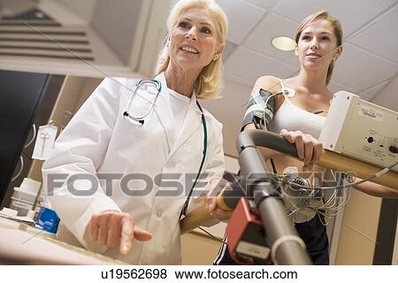 Stock Photo - Doctor Monitoring The Heart-Rate Of Patient On A Treadmill. Fotosearch