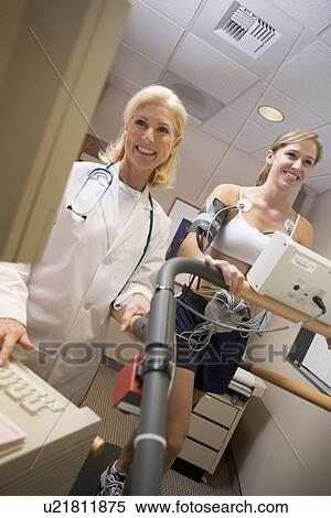 Stock Photography - Doctor Monitoring The Heart-Rate Of Patient On A Treadmill. Fotosearch