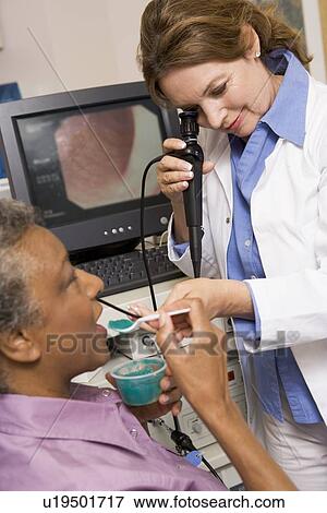 Stock Photo - Doctor Performing Check-Up On Patient. Fotosearch