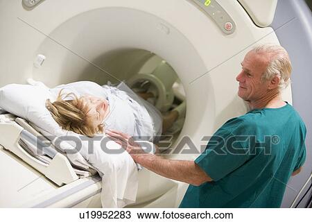 Stock Image - Doctor With Patient As They Prepare For A Computerized Axial Tomography (CAT) Scan. Fotosearch