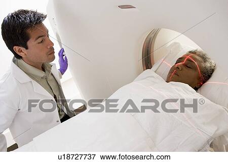 Doctor With Patient Having A Computerized Axial Tomography (CAT) Scan View Large Photo Image Stock Photo - Doctor With Patient Having A Computerized Axial Tomography (CAT) Scan. Fotosearch