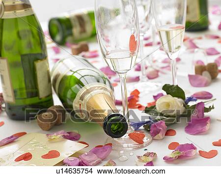 Picture - Empty Wine Bottles Among Rose Petals. Fotosearch