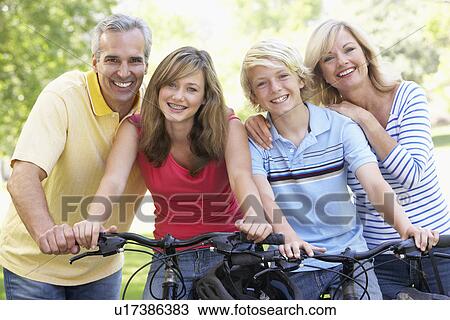 Stock Image - Family Cycling Through A Park. Fotosearch