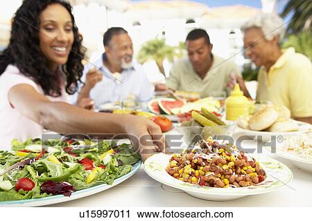 Stock Image - Family Eating An Al Fresco Meal. Fotosearch