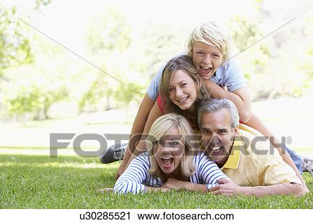 Stock Image - Family Lying On Top Of Each Other In A Park. Fotosearch