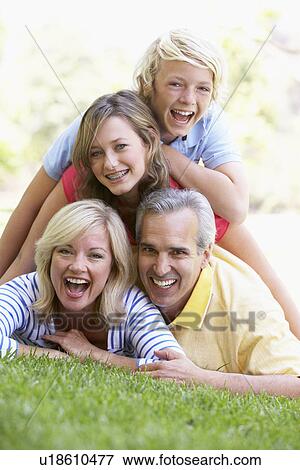 Stock Photo - Family Lying On Top Of Each Other In A Park. Fotosearch
