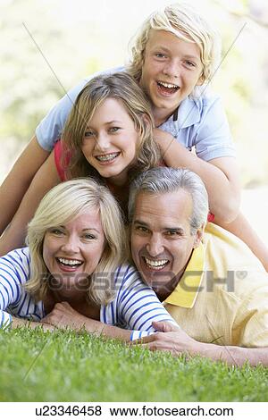 Stock Photo - Family Lying On Top Of Each Other In A Park. Fotosearch
