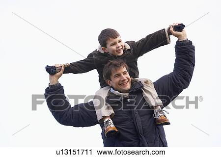 Stock Image - Father Carrying Son On His Shoulders. Fotosearch