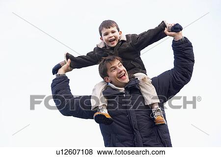 Stock Photo - Father Carrying Son On His Shoulders. Fotosearch