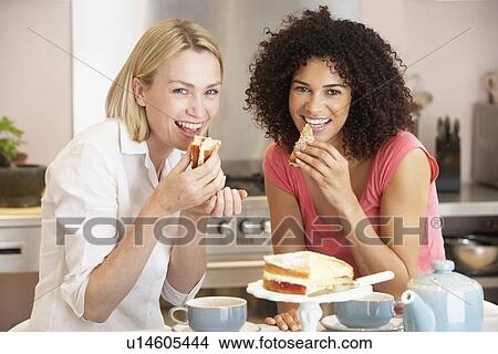 Picture - Female Friends Enjoying Tea And Cake At Home. Fotosearch