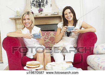 Female Friends Enjoying Tea And Cake At Home View Large Photo Image Stock Photo - Female Friends Enjoying Tea And Cake At Home. Fotosearch
