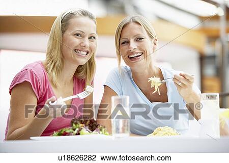 Stock Image - Female Friends Having Lunch Together At The Mall. Fotosearch