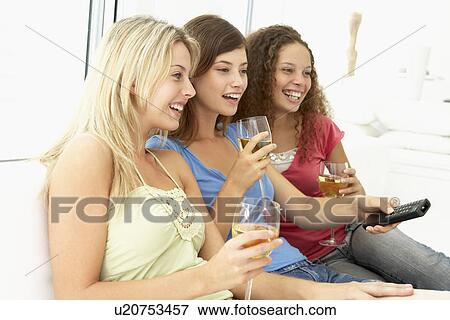 Stock Photo - Female Friends Watching Television Together. Fotosearch