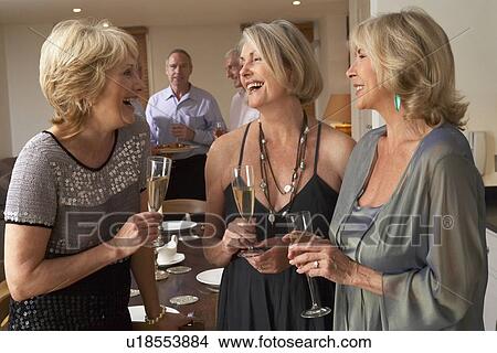 Picture - Friends Enjoying A Glass Of Champagne At A Dinner Party. Fotosearch