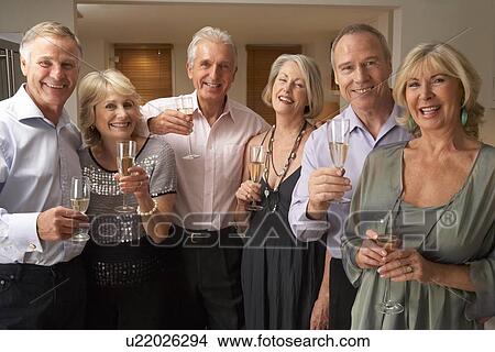 Picture - Friends Enjoying A Glass Of Champagne At A Dinner Party. Fotosearch