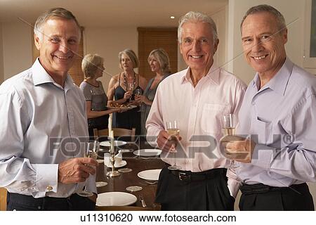 Stock Image - Friends Enjoying A Glass Of Champagne At A Dinner Party. Fotosearch