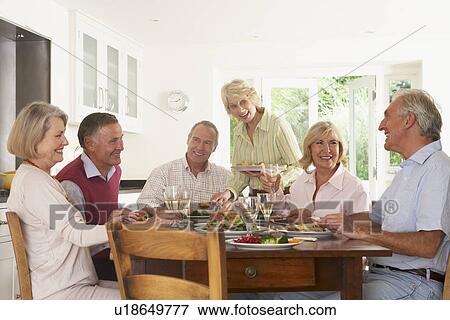 Stock Photo - Friends Enjoying Lunch At Home Together. Fotosearch