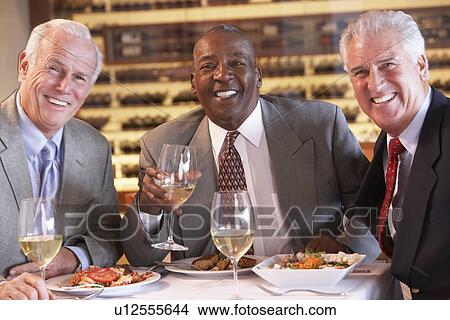 Picture - Friends Having Dinner Together At A Restaurant. Fotosearch