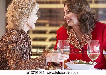 Stock Image - Friends Having Dinner Together At A Restaurant. Fotosearch
