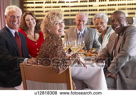 Stock Photo - Friends Having Dinner Together At A Restaurant. Fotosearch