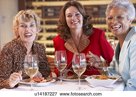 Stock Photo - Friends Having Dinner Together At A Restaurant. Fotosearch