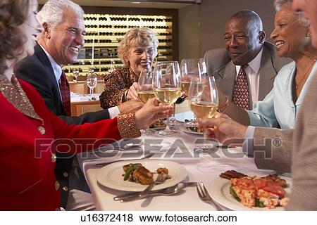 Stock Photo - Friends Having Dinner Together At A Restaurant. Fotosearch