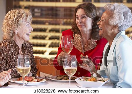 Stock Photo - Friends Having Dinner Together At A Restaurant. Fotosearch