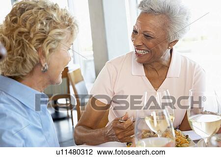 Stock Image - Friends Having Lunch Together At A Restaurant. Fotosearch