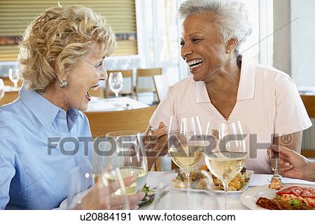 Stock Image - Friends Having Lunch Together At A Restaurant. Fotosearch