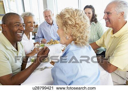 Stock Image - Friends Having Lunch Together At A Restaurant. Fotosearch