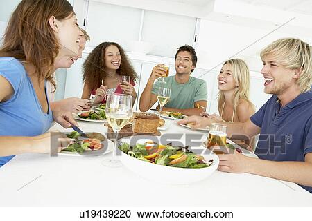 Stock Image - Friends Having Lunch Together At Home. Fotosearch